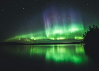 calm body of water under aurora lights