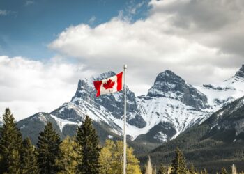 us a flag on pole near snow covered mountain