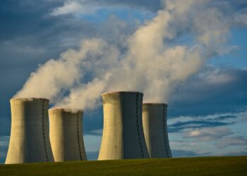 gray concrete towers under white clouds and blue sky during daytime