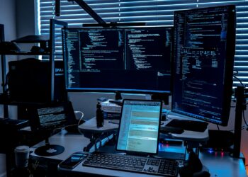 a desk with several monitors