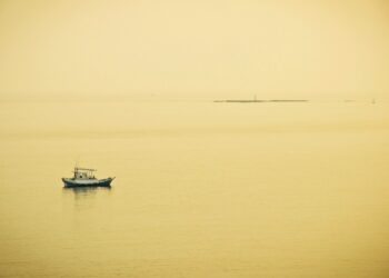 a small boat floating on top of a large body of water