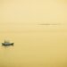 a small boat floating on top of a large body of water