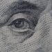 Detailed close-up of an illustration from a dollar bill, focusing on intricate line work.