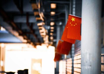 a chinese flag hanging from the side of a building