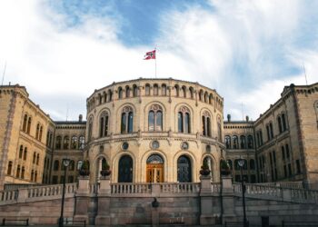 Parliament building with the norwegian flag waving.