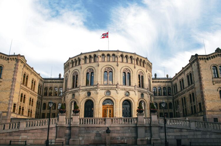 Parliament building with the norwegian flag waving.