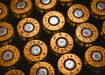 A close-up view of brass 45 auto cartridge casings arranged in a grid