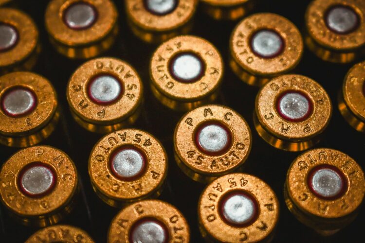 A close-up view of brass 45 auto cartridge casings arranged in a grid