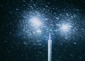 a street light in the snow at night