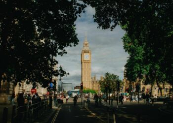Iconic big ben tower framed by lush green trees