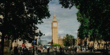 Iconic big ben tower framed by lush green trees