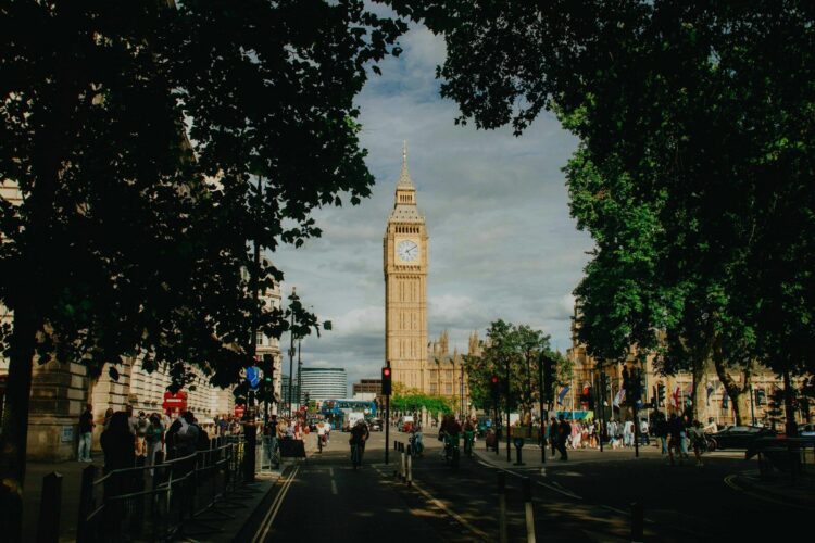 Iconic big ben tower framed by lush green trees