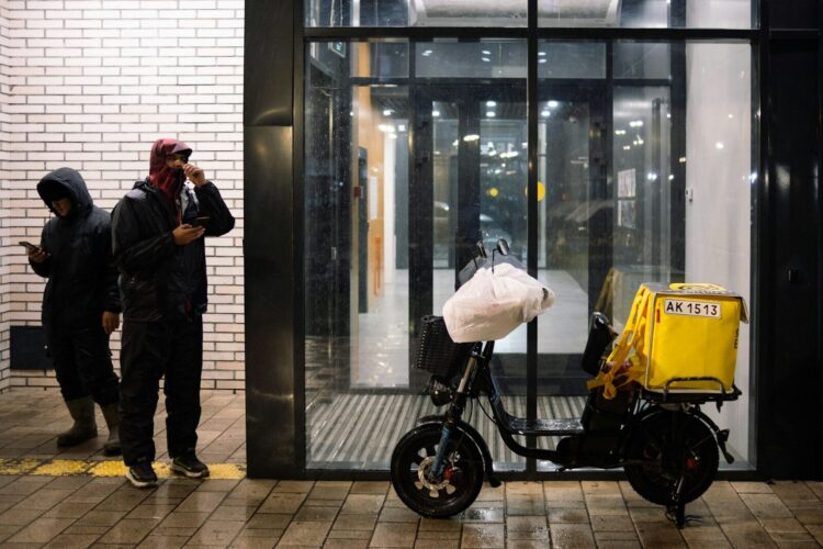 A man standing next to a motorcycle in front of a building