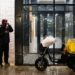 A man standing next to a motorcycle in front of a building